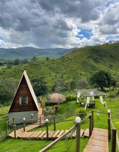 a small cabin in a field with a hill at Cabana com Vista para SERRA da Canastra in São Roque de Minas
