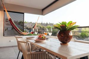 威廉斯塔德2BR LXRY Jansofat tropic oasis apt & pool的一张桌子,上面放着一碗水果和花瓶