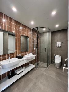 a bathroom with two sinks and a shower and a toilet at Hillside Luxury Apartments by CASEPIA in Phu Quoc