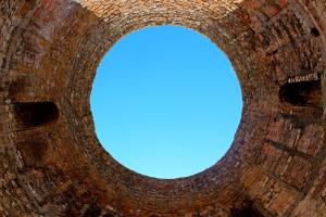 a hole in a brick wall with a blue sky at Classy Apartment Center in Split
