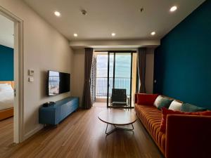 a living room with a couch and a table and a television at Hillside Luxury Apartments by CASEPIA in Phu Quoc +2 photos