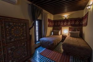 Postel nebo postele na pokoji v ubytování Riad Les Remparts De Fès
