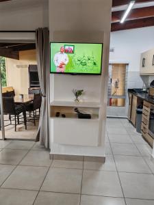 a living room with a flat screen tv on a wall at 37 Chakas Rock Chalets in Ballito