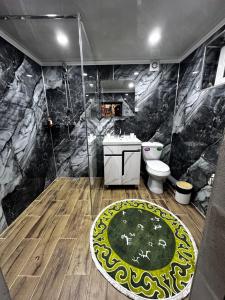 a bathroom with a shower and a toilet and a rug at Ethnochill Karakol yurt camping in Karakol