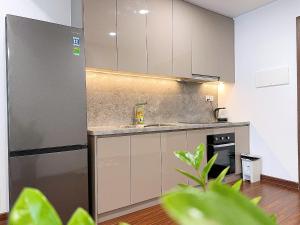 a kitchen with white cabinets and a stainless steel refrigerator at Căn Hộ 2 Phòng Ngủ LUXURY-1816 in Gia Lâm Pho