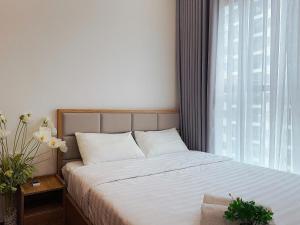 a bedroom with a bed with white sheets and a window at Căn Hộ 2 Phòng Ngủ LUXURY-1816 in Gia Lâm Pho