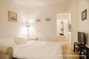a bedroom with a white bed and a television at Casa Azzurra in Menaggio