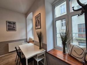 a dining room with a table and a window at Five Rooms Piotrkowska 28 in Łódź