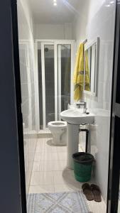 a white bathroom with a sink and a toilet at RESIDENCE ADSL Studio Dakar in Dakar