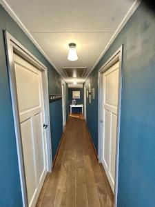 a hallway with blue walls and two doors at Bovenop 19 in Hippolytushoef