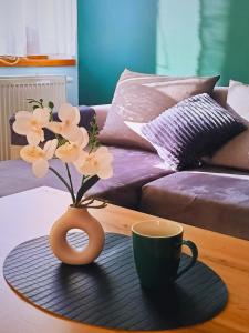 wazon z kwiatami i kubek na stole w obiekcie Okno na Śnieżkę, Apartament z 2 Łazienkami, tarasem, ogrodem, parkingiem i pięknym widokiem w mieście Karpacz