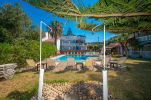 a pool with chairs and a table and a house at Markella Maisonette Hotel Complex in Marathias