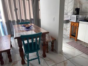 a kitchen with a wooden table and two chairs at Apto Bela Vista 10 in Pôrto Ferreira