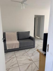 a living room with a couch and a television at Apto Bela Vista 10 in Pôrto Ferreira +2 photos