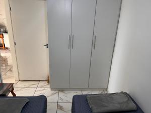 a room with two white cabinets and a bed at Apto Bela Vista 10 in Pôrto Ferreira