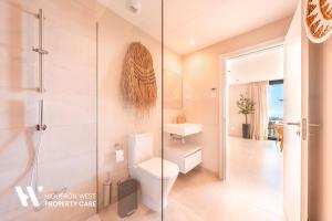 a bathroom with a toilet and a glass shower at Higueron West Property Collection - La CostaVale by HWPC in Fuengirola +33 photos