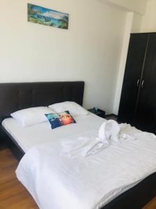 a white bed with a pillow on top of it at Klara Central in Constanţa