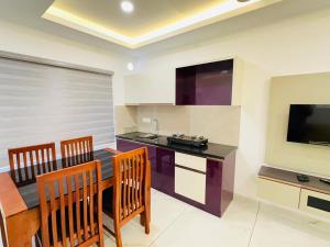a kitchen and dining room with a table and chairs at Stanley's Residency in Edappally