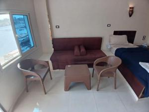 a living room with a couch and a bed and chairs at Nile Moon in Jazīrat Aswān