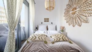 a bedroom with a bed and a large window at Hevenia, Sun & Snow in Mrzeżyno