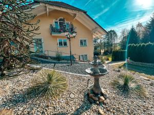 ein Haus mit einem Brunnen in einem Kieshof in der Unterkunft Panorama-Refugium in Bad Koetzting