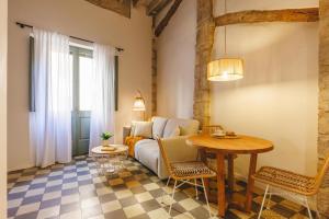a living room with a couch and a table at Bravissimo Calderers La Lleona, heart of the Barri Vell in Girona
