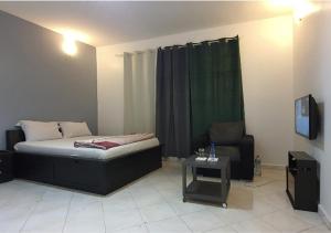 a bedroom with a bed and a chair and a tv at RESIDENCE ADSL Studio Dakar in Dakar