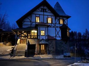 a large house with lights on at night at Villa Petzold in Spiegelau