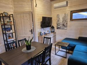 a living room with a table and a blue couch at Dzik w zagrodzie in Borsk