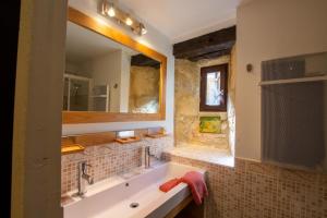 un bagno con un lavandino e un grande specchio di La pomponnaise a Saint-Pompont Altre 15 foto