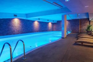 a swimming pool in a building with blue lighting at GRANO HOTEL Gdańsk Riverside in Gdańsk