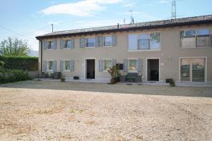 a large house with a gravel yard in front of it at Casale la Coccinella Gelsomino in Caprino Veronese