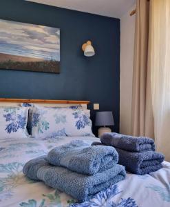 ein Schlafzimmer mit einem Bett mit Handtüchern darauf in der Unterkunft Sandpiper Cottage: cosy home near the beach in Woolacombe