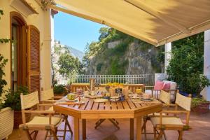 un tavolo e sedie di legno su un patio di Villa D'apuzzo nel cuore di Positano a Positano