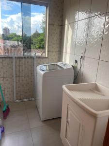 a washing machine in a bathroom with a window at Apartamento Aconchegante 2 Quartos in Tabapira +6 photos
