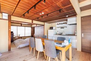 una cucina e una sala da pranzo con tavolo e sedie in legno di Manabi-stay Matsue 駅近伊勢宮町どこに行くにも最高に便利な古民家一棟貸切ホテル a Matsue