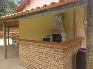 an outdoor kitchen with a brick oven in a house at Sitio Oliveira in Araras Petropolis