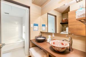 un bagno con lavandino e specchio di Manabi-stay Matsue 駅近伊勢宮町どこに行くにも最高に便利な古民家一棟貸切ホテル a Matsue Altre 37 foto