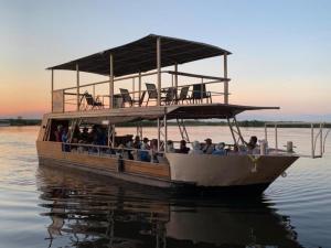 un gruppo di persone su una barca sull'acqua di Nxabii Cottages a Kasane
