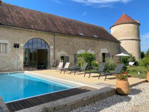 a house with a swimming pool in front of a building at Abbaye de Reigny - Esprit de France in Vermenton