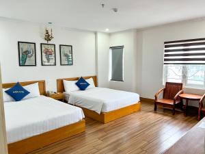 a hotel room with two beds and a chair at HaTa Hotel in Quy Nhon +55 photos