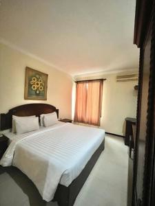 Postel nebo postele na pokoji v ubytování Tuwuh Hotel at Kayutangan
