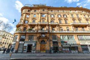 a large yellow building on the corner of a street at Rome As You Feel - Charming Space at Torre Argentina in Rome