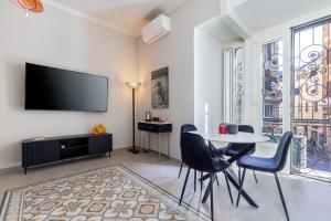 a living room with a table and chairs and a tv at Rome As You Feel - Charming Space at Torre Argentina in Rome