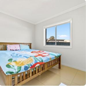 a bedroom with a bed and a window at 2-bedroom Granny Flat in Mount Pritchard
