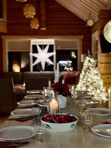 una mesa de comedor con un árbol de Navidad en un restaurante en Tuovilan Lomamökki - Hot Tub - Lakeside log cabin, en Kuusamo