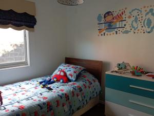 a bedroom with a bed with a stuffed animal on it at Casa chiloe castro in Castro