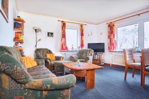 a living room with chairs and a table and a tv at Meerblick Hohenfelde in Monkamp