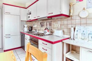 a kitchen with white cabinets and a red counter top at Meerblick Hohenfelde in Monkamp