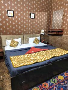 Bahādurgarhにあるhotel Metroview room&celebrationのベッドルーム1室(青と金のシーツが備わるベッド1台付)